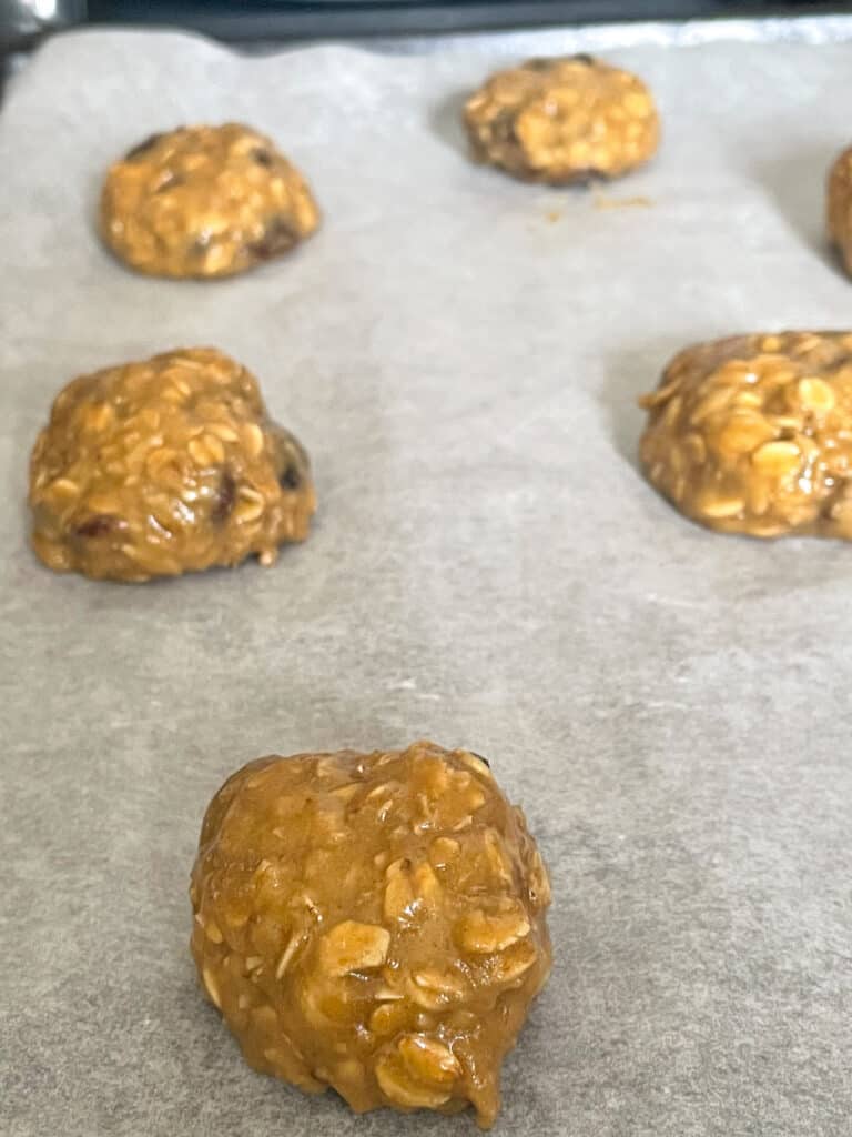 oatmeal raisin cookie unbaked dough balls on baking tray.