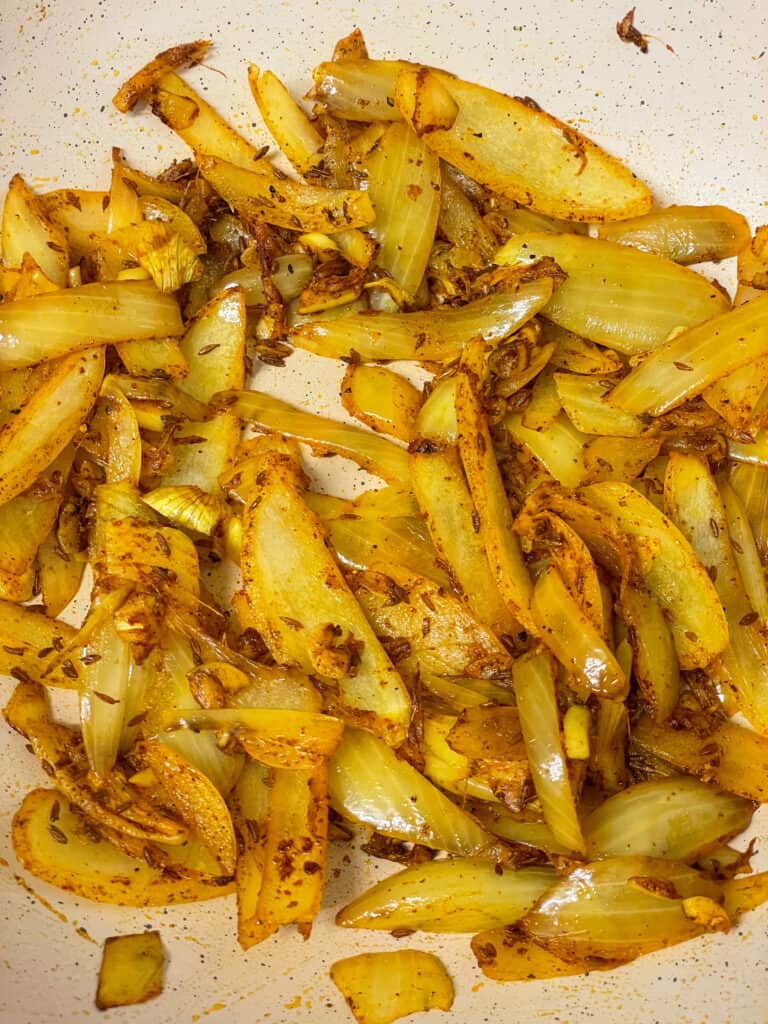 onions and spices cooking in pan for Aloo Gobi.