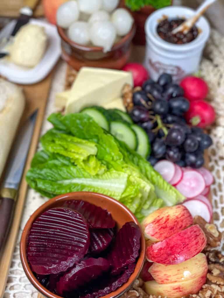 vegan ploughman's platter filled with fruit, veggies, pickles and vegan cheese.