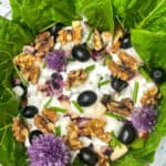 close up photo of vegan Waldorf salad in bowl, with white and strawberry patterned tablecloth background.