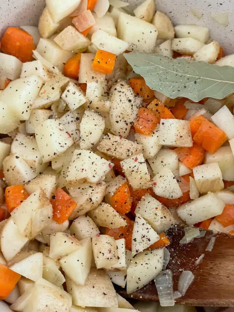 Bay leaf, salt and pepper added to soup pot.