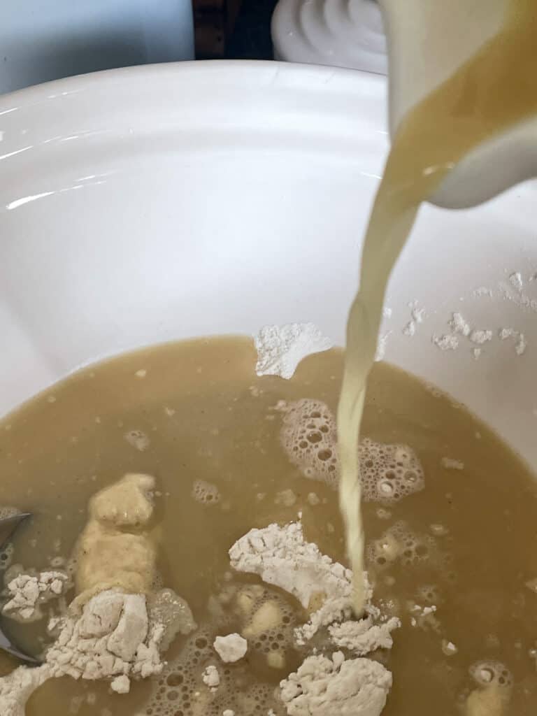 Milk pouring into flour in the mixing bowl.