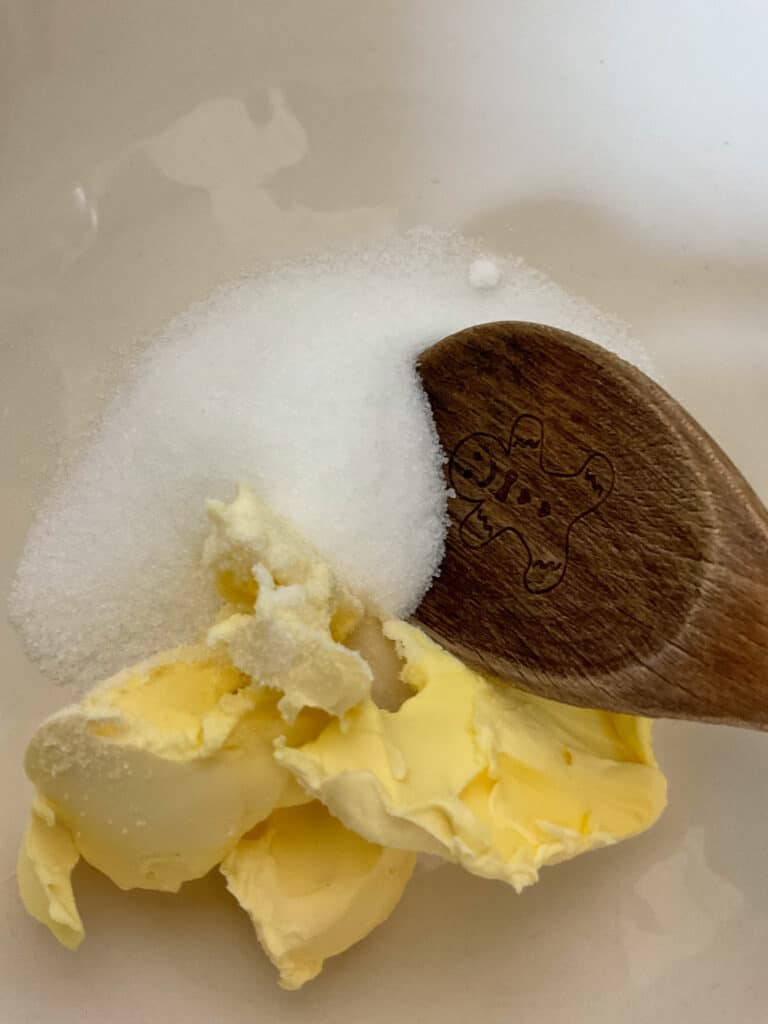 margarine and sugar in the mixing bowl with a wooden spoon.