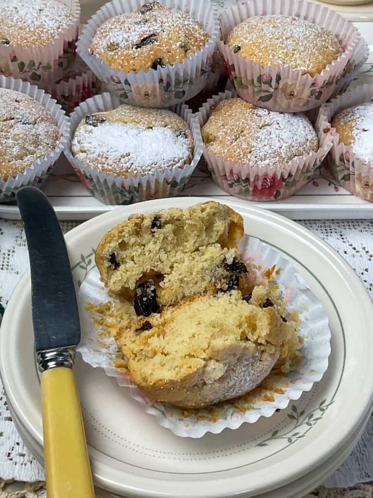 Granny cake sliced open on small plate with yellow handled butter knife.