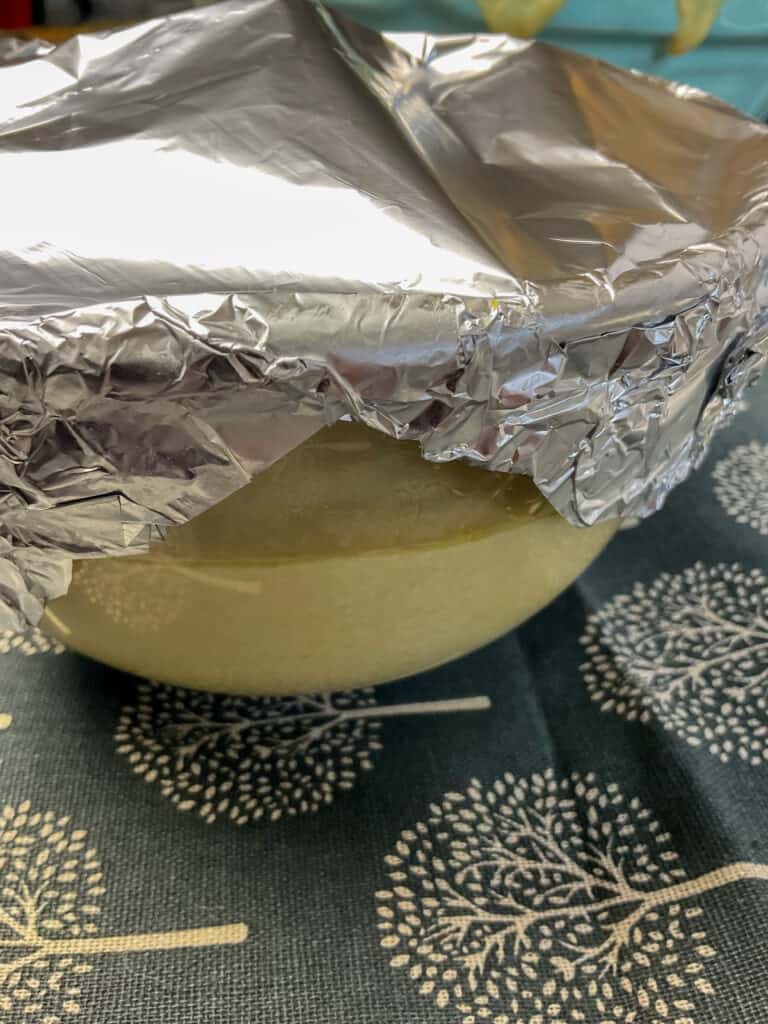 side of pudding bowl covered with kitchen foil.