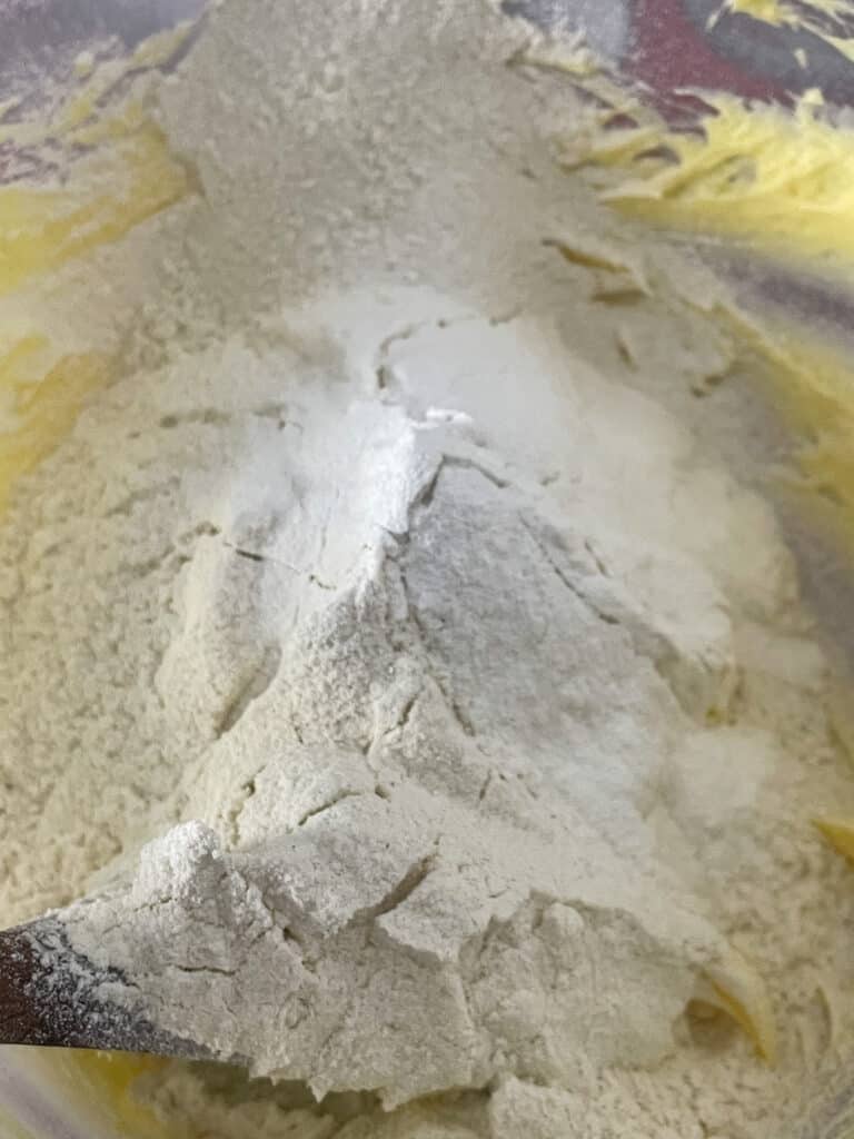 flour and baking powder added to creamed margarine in mixing bowl.