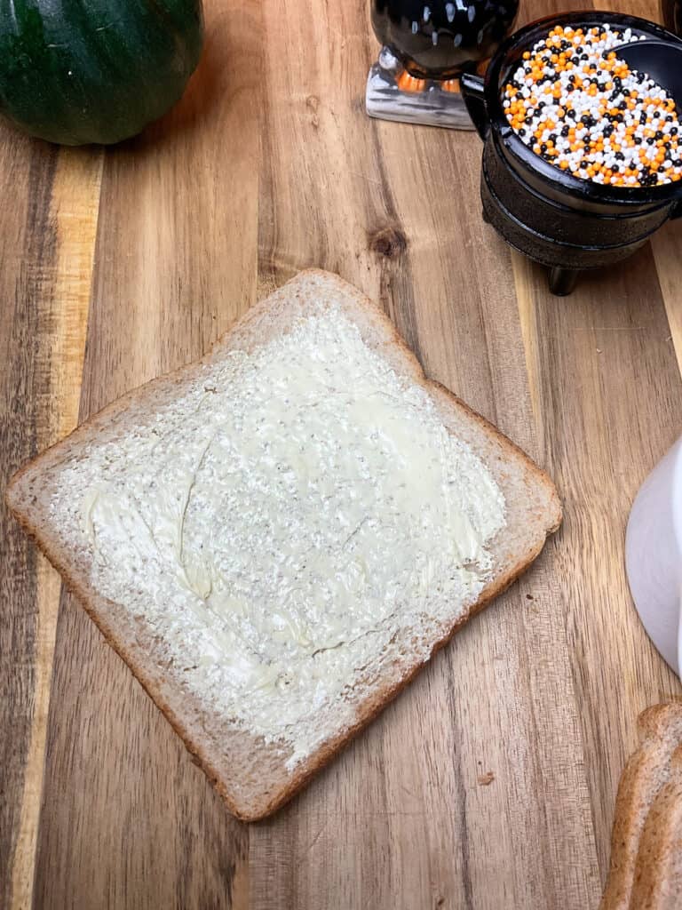 vegan butter spread over slice of bread on chopping board.