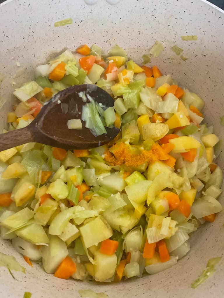Diced veggies sautéed in pot.