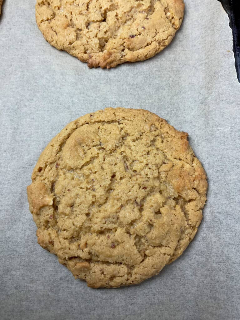 close up of peanut butter cookie on parchment paper.