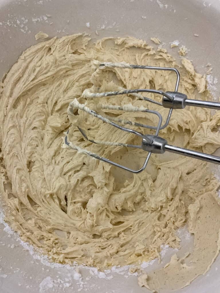 cinnamon buttercream frosting mixed and ready to use in the mixing bowl.