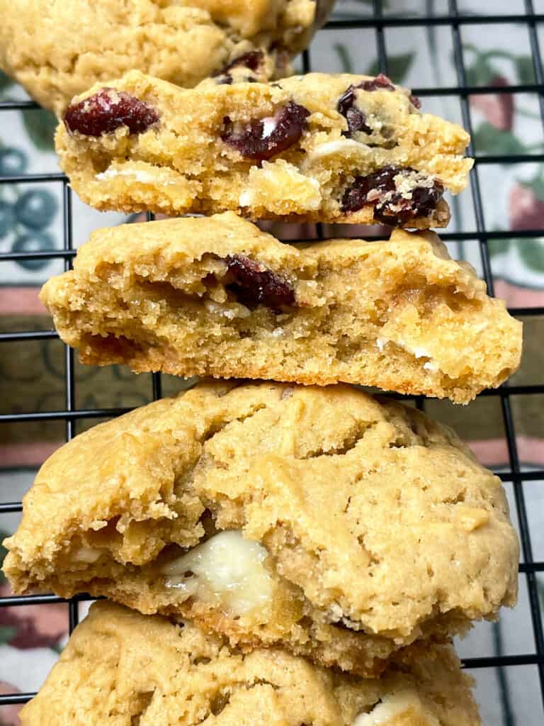 white chocolate and cranberry cookies sliced into pieces to see the inside texture, on a wire rack.