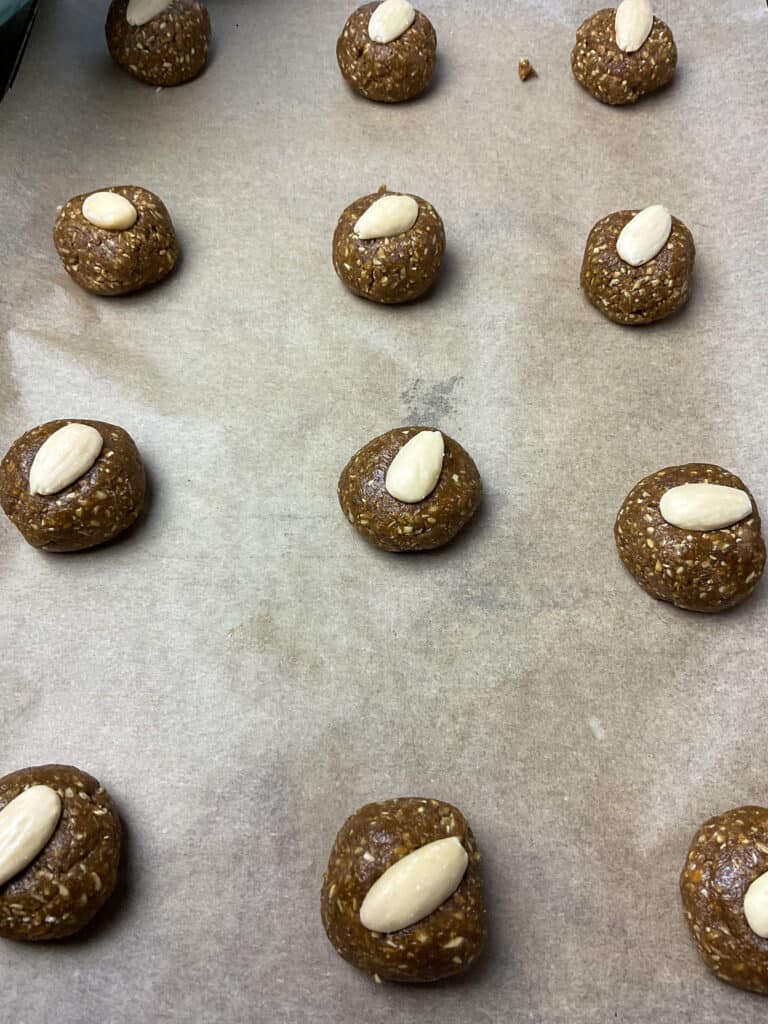 Almond pressed into each unbaked parkin biscuit ball.