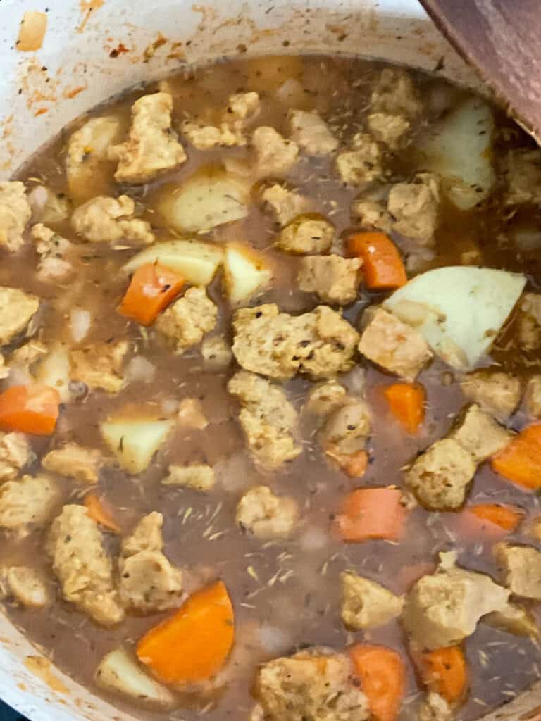 veggie stocked added to stew pot ready to bring to the boil and cook the filling for vegan meat and potato pie.