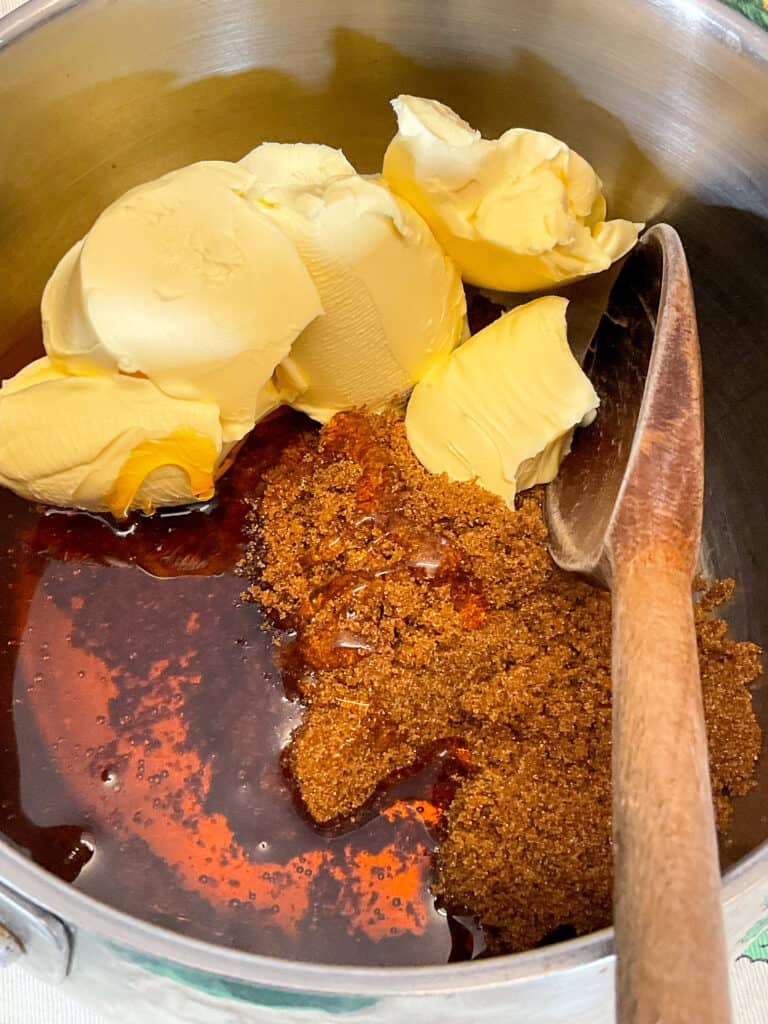 gingerbread men ingredients in saucepan melting with wooden spoon stirring.