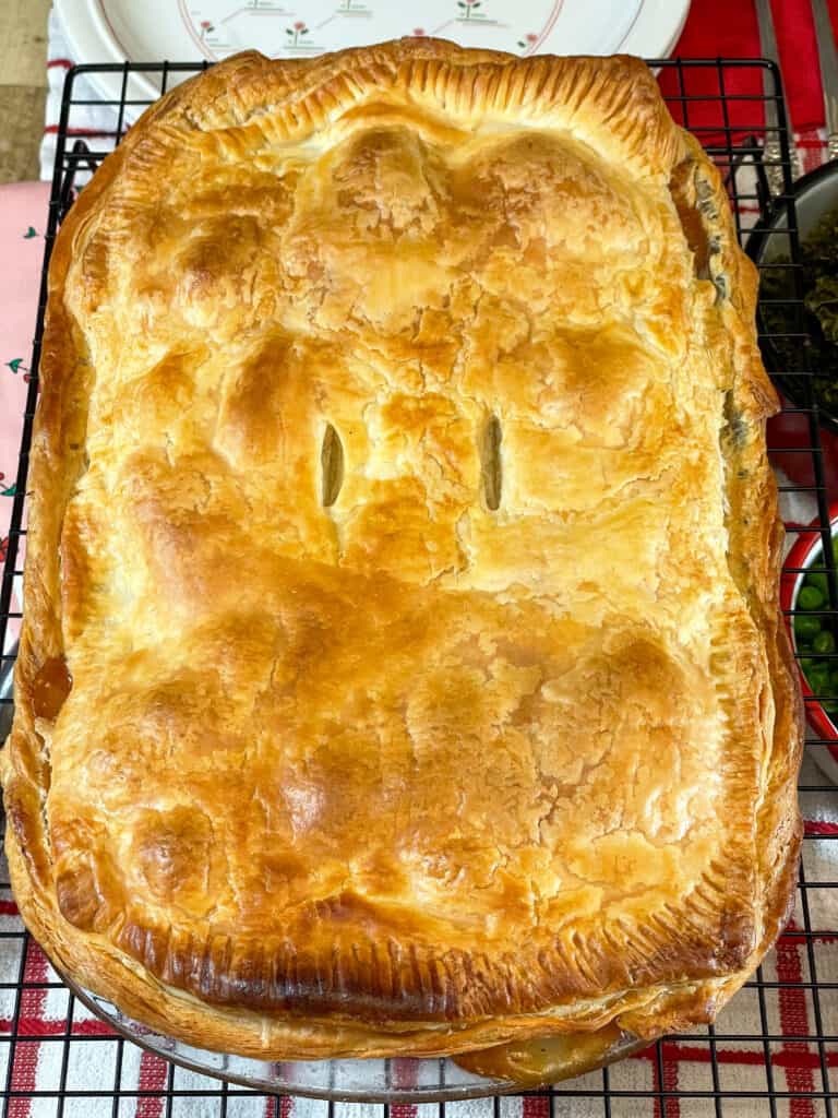 veggie meat and potato pie baked and cooling on wire rack with red and white check tea towel underneath.