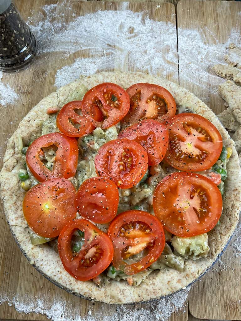 sliced tomatoes covering  unbaked homity pie.