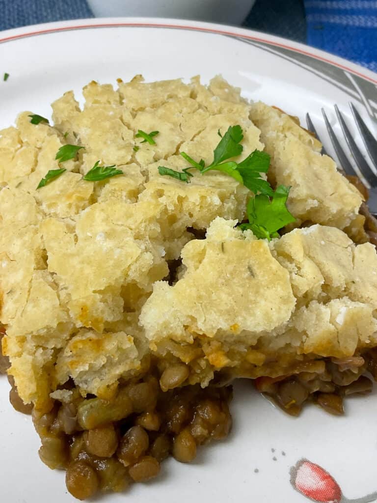 A serving of vegan Teviotdale pie on dinner plate with silver fork to side.