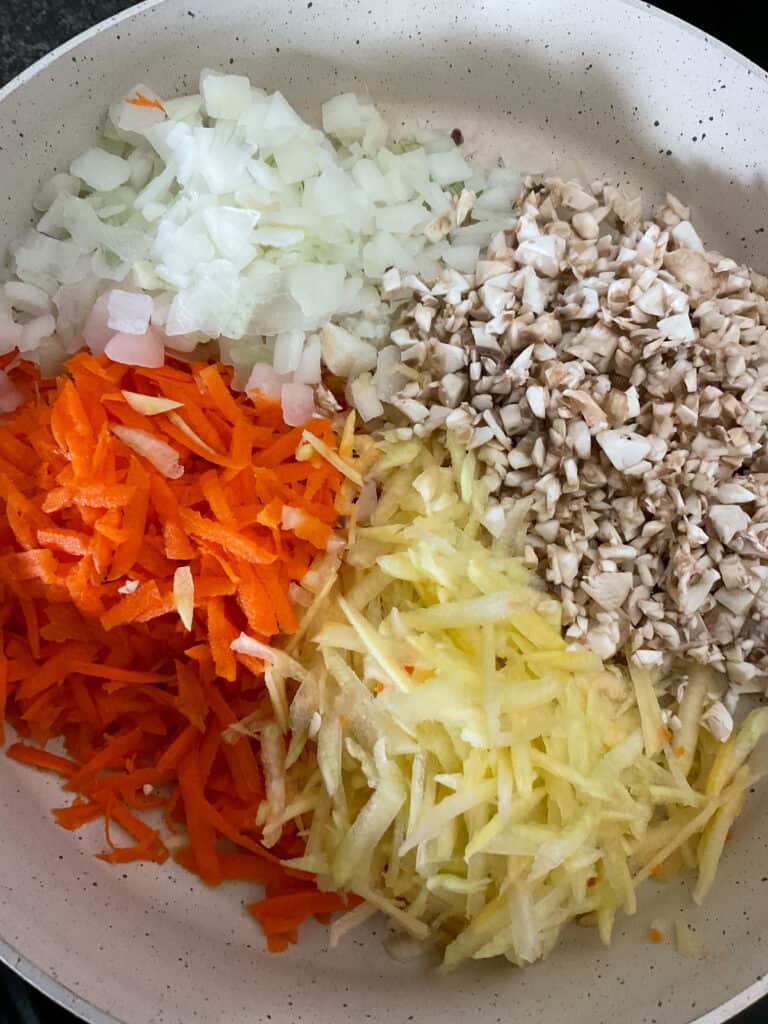 fine diced and grated veggies cooking in skillet.