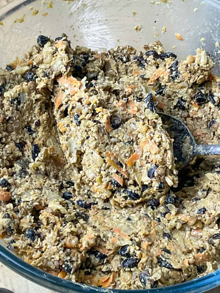 vegan haggis ingredients stirred together in a glass mixing bowl.