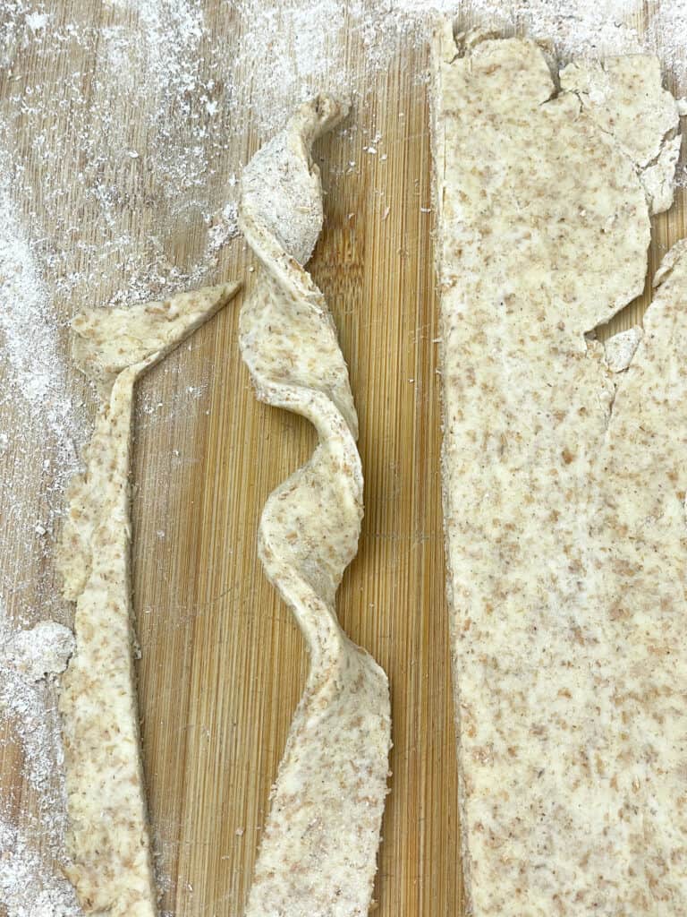 rolled pastry stick twisted into spiral shape on cutting board.