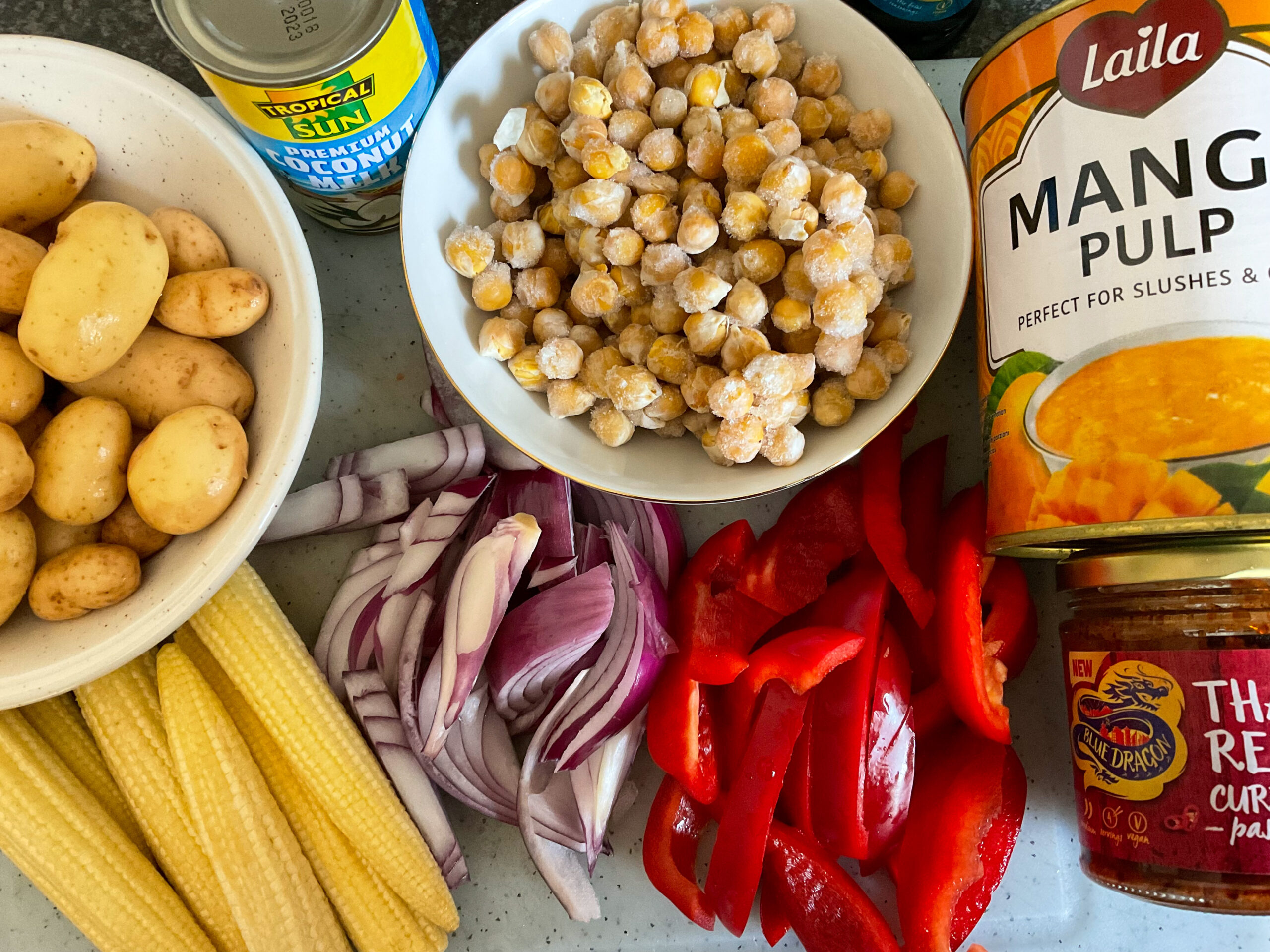 Mango curry ingredients on white cutting board.