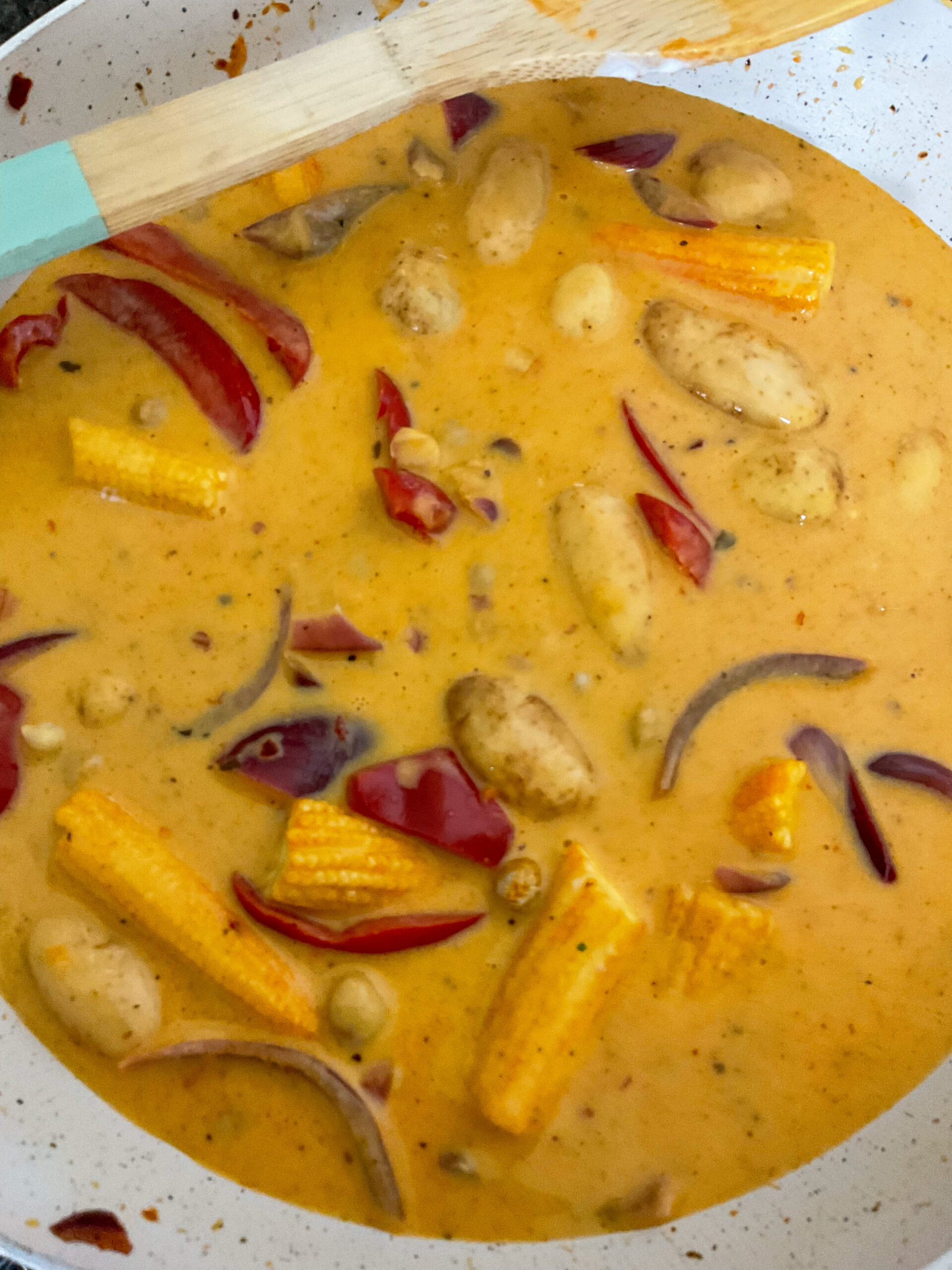 Liquid added to mango curry in pan.