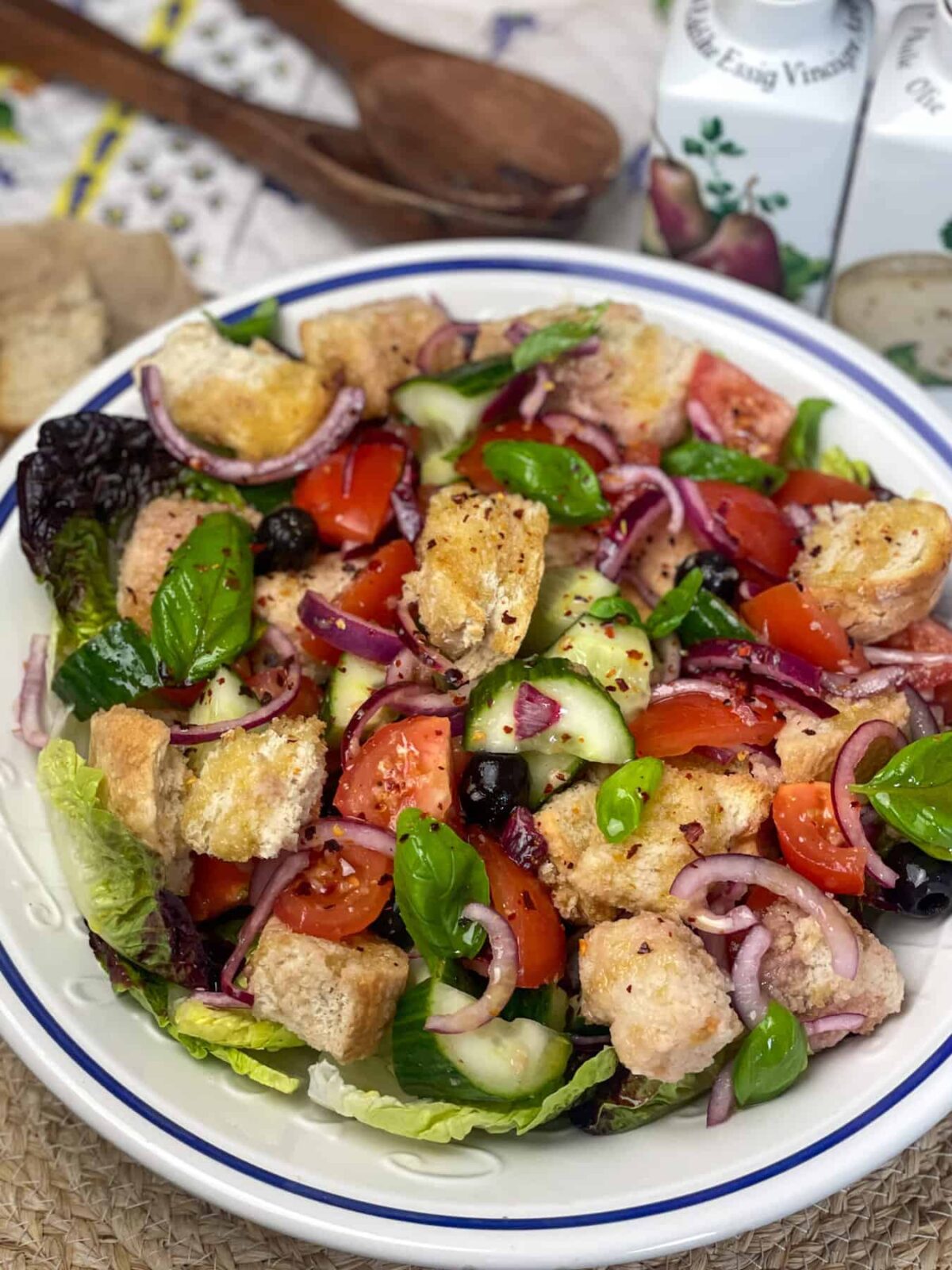 A close up photo of a blue rimmed bowl of bread salad.