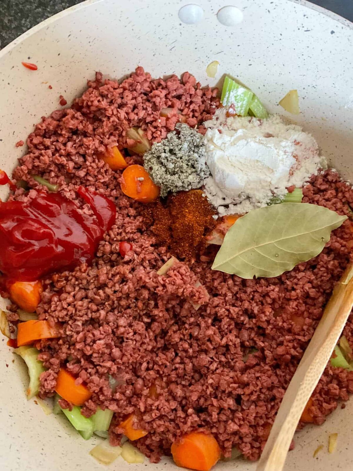 Vegan mince, seasonings, ketchup and flour added to the vegetables in the stew pot.