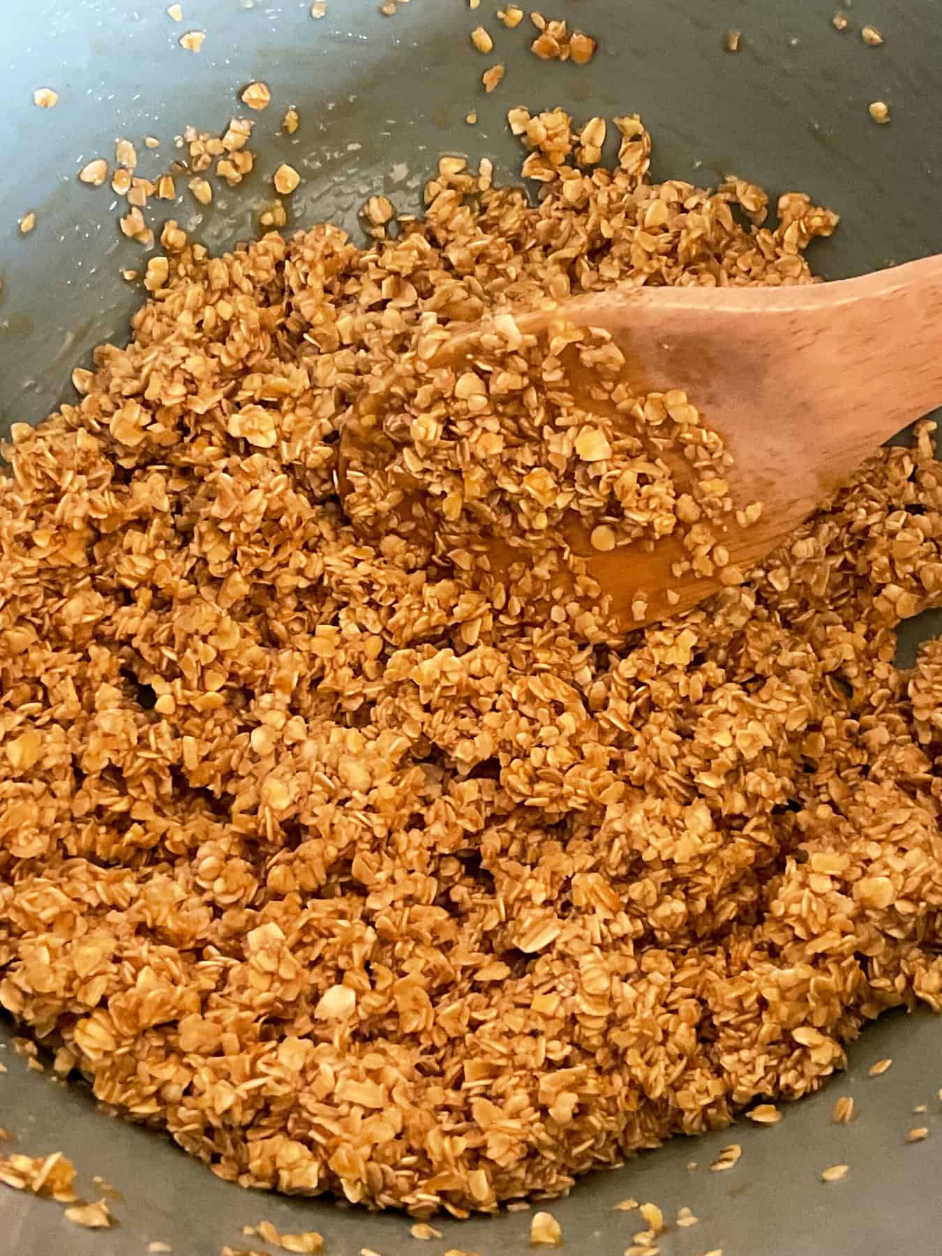 Melted syrup added and stirred through the rolled oats in mixing bowl.