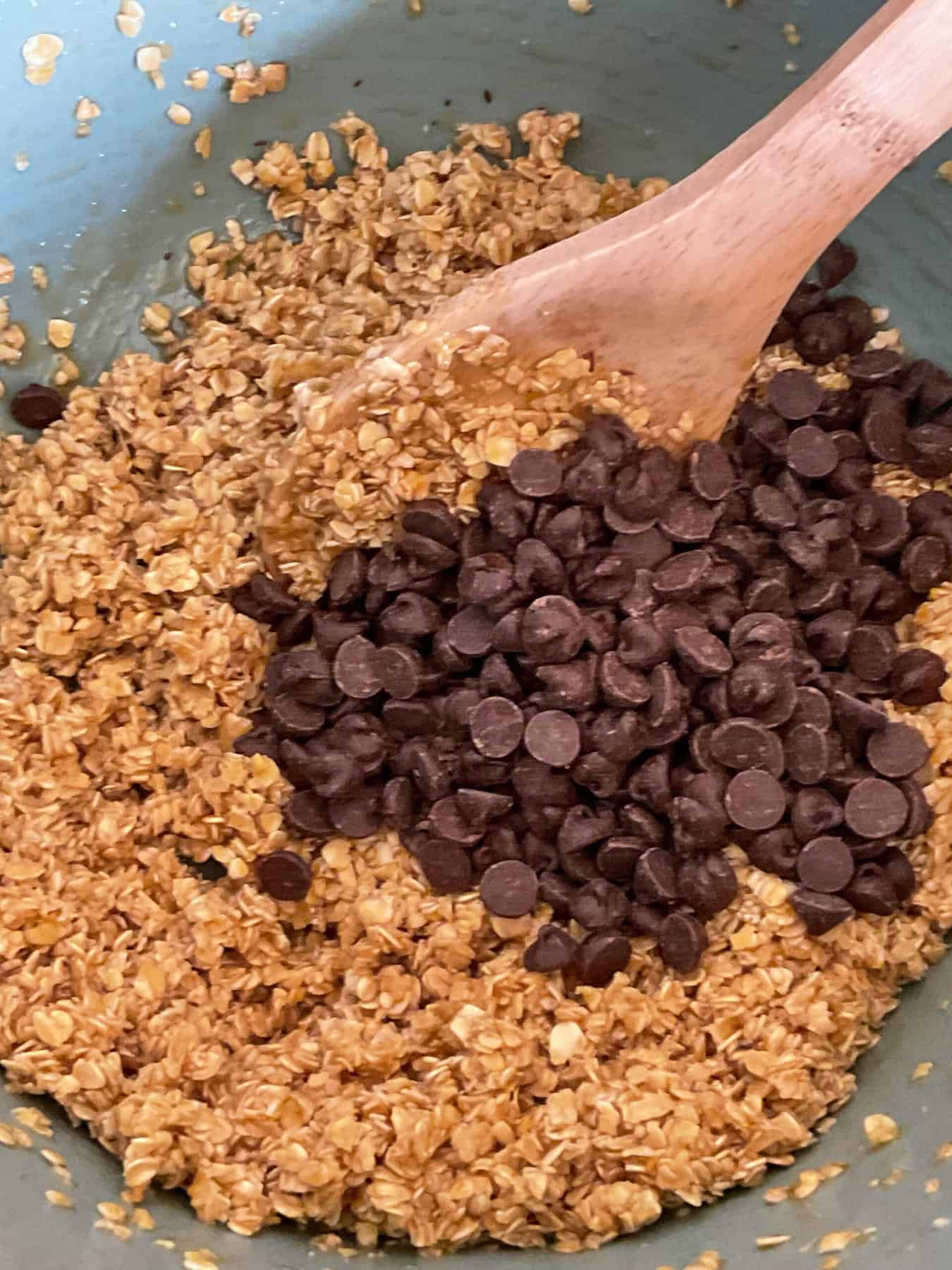 Chocolate drops added to mixed ingredients for chocolate flapjacks.