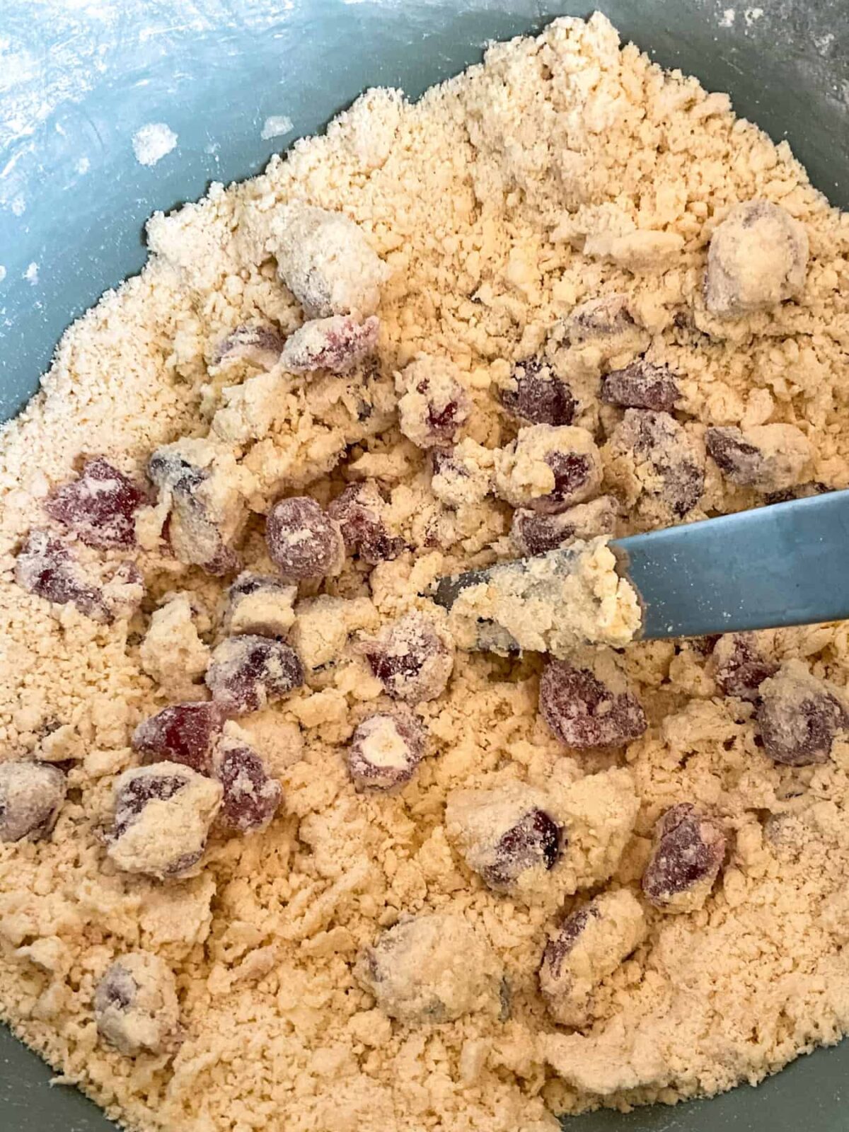 Milk stirred through the cherries and crumbed mixture with a cutlery knife.