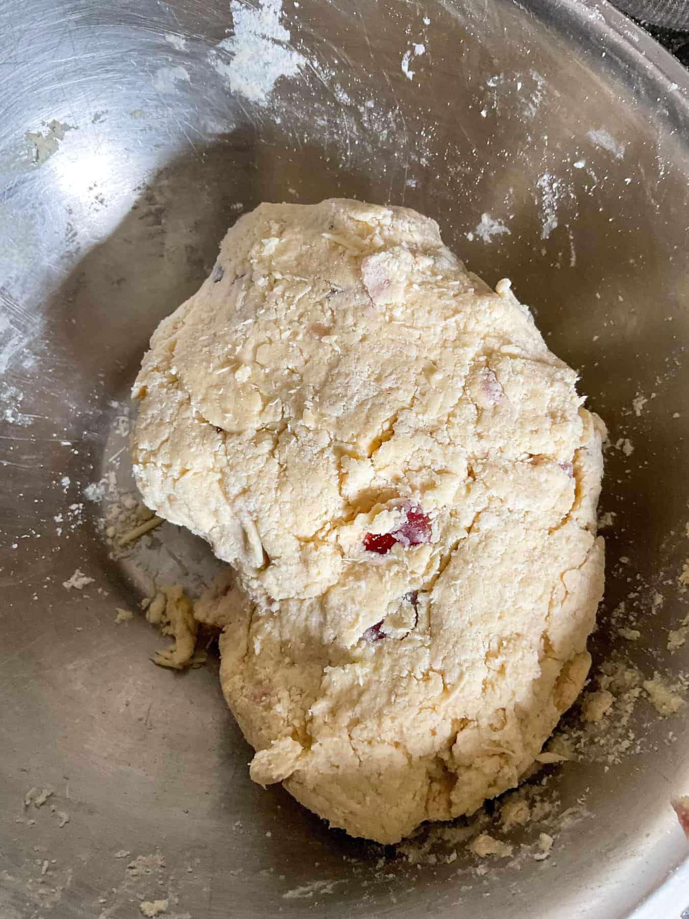 Cherry scone dough brought together into a dough in mixing bowl.