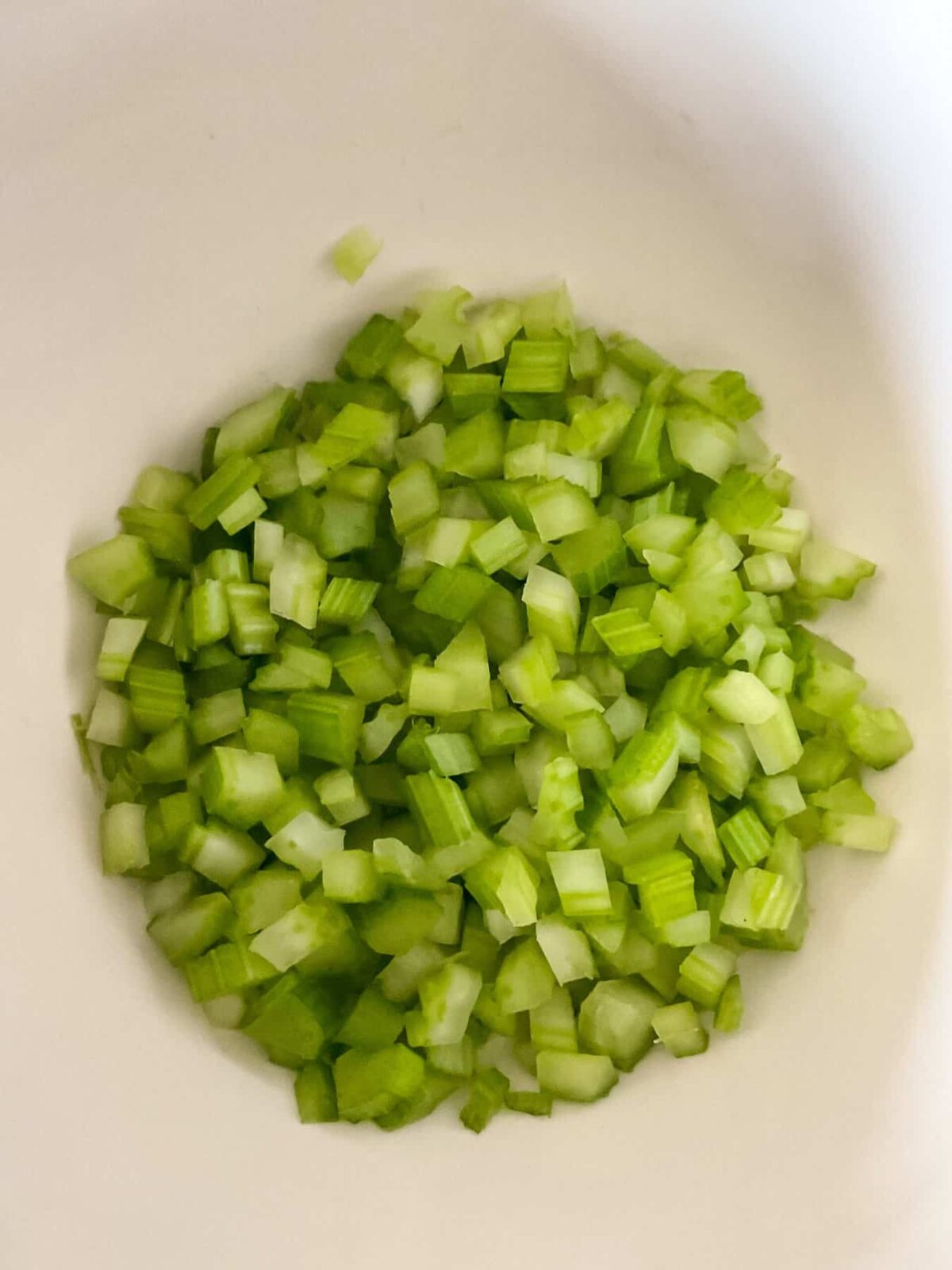 Fine diced celery in a mixing bowl.