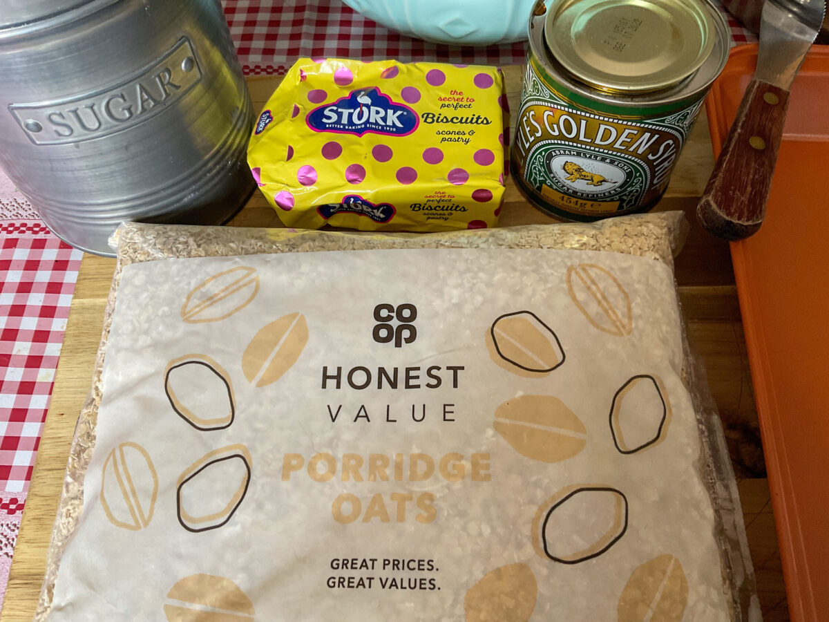 traditional Scottish flapjacks ingredients on a wooden cutting board.