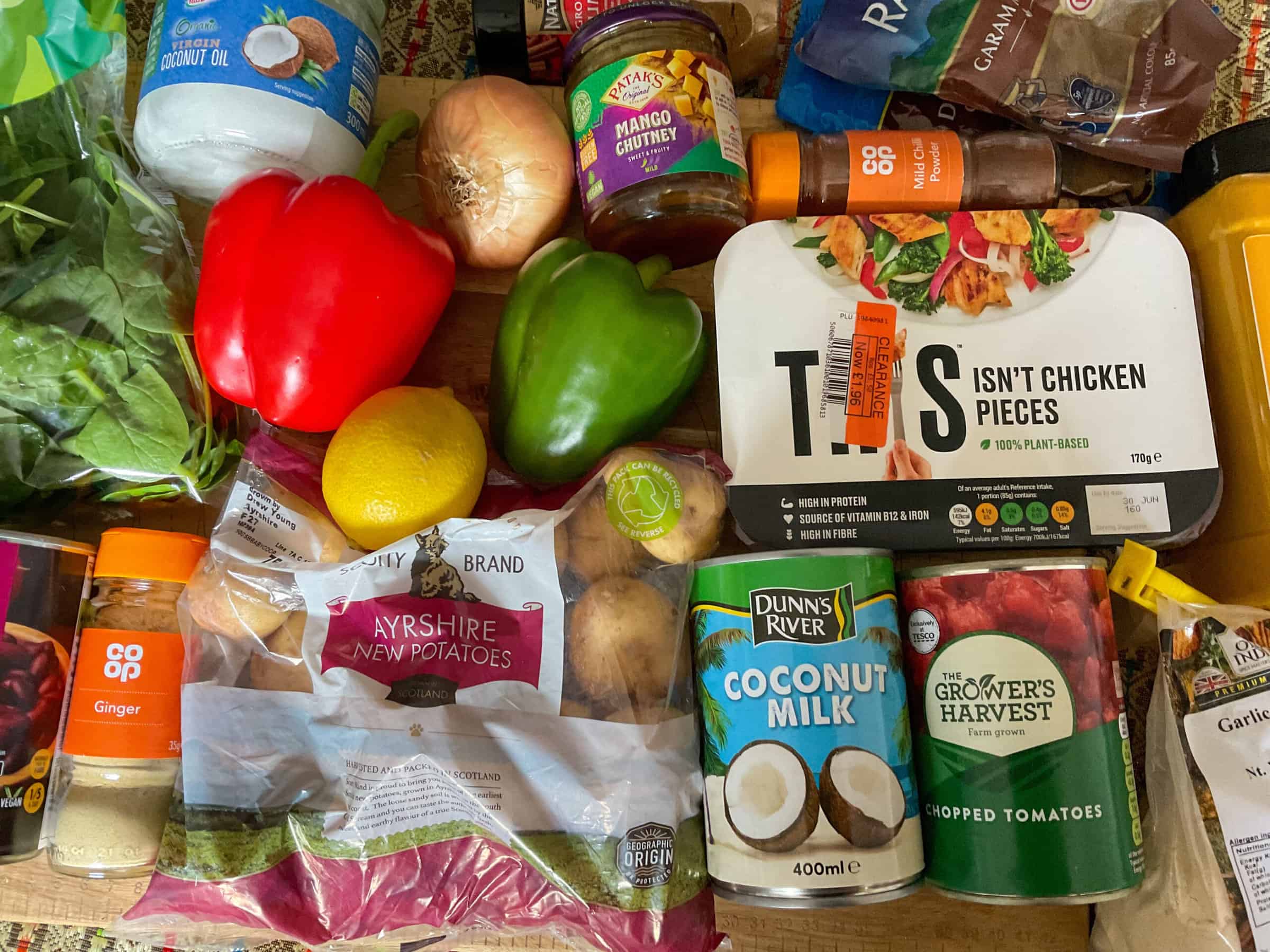 Ingredients for vegan jalfrezi curry on a wooden cutting board.