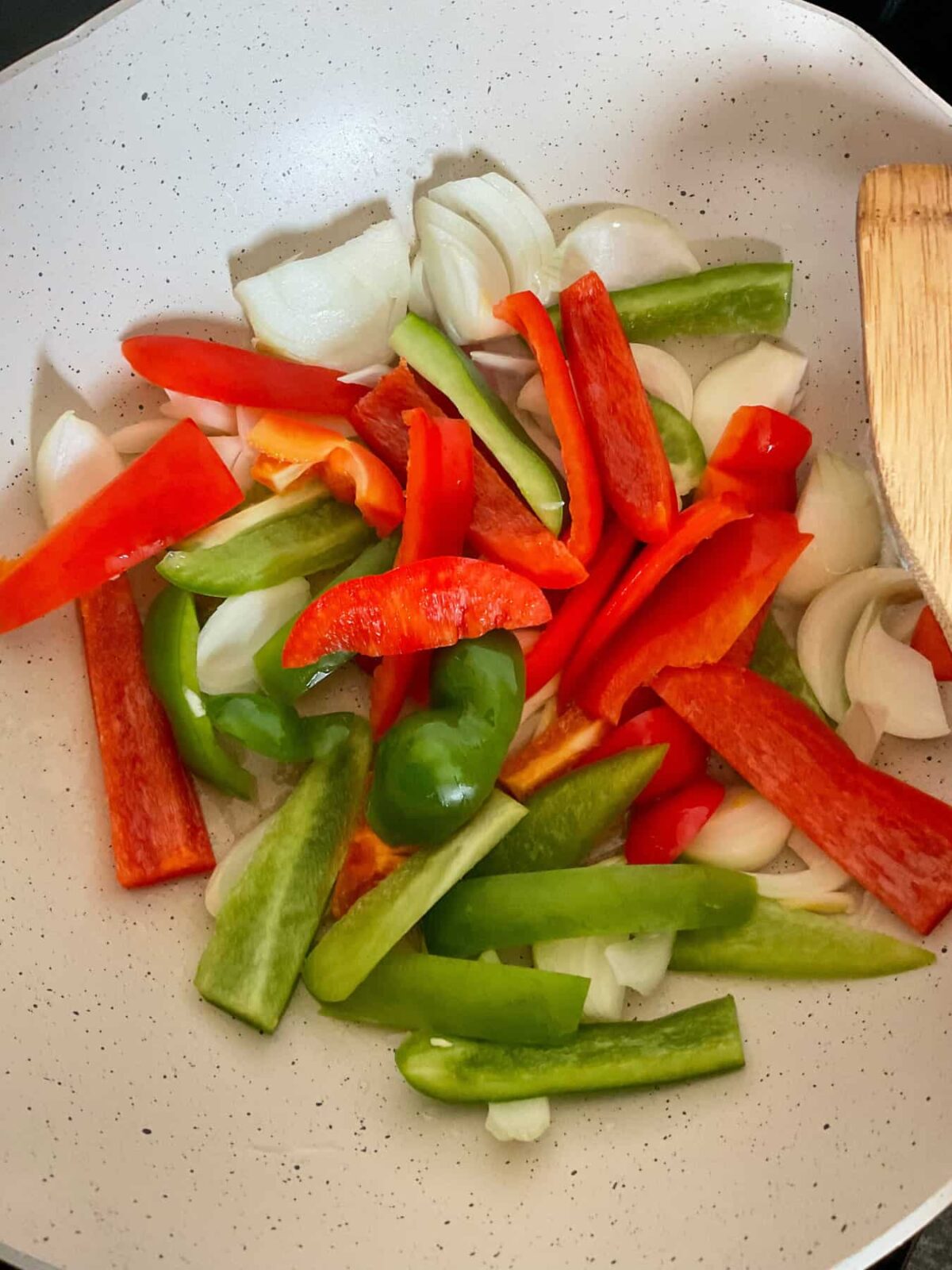 Bell peppers and onion slices stir-frying in Wok.