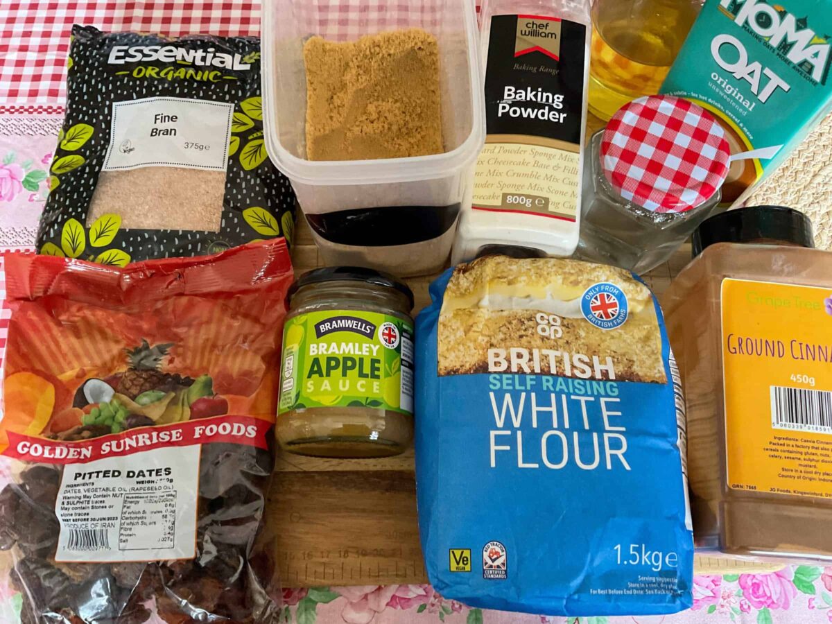 Ingredients for bran muffins on a wooden board, with red and white check table cloth.