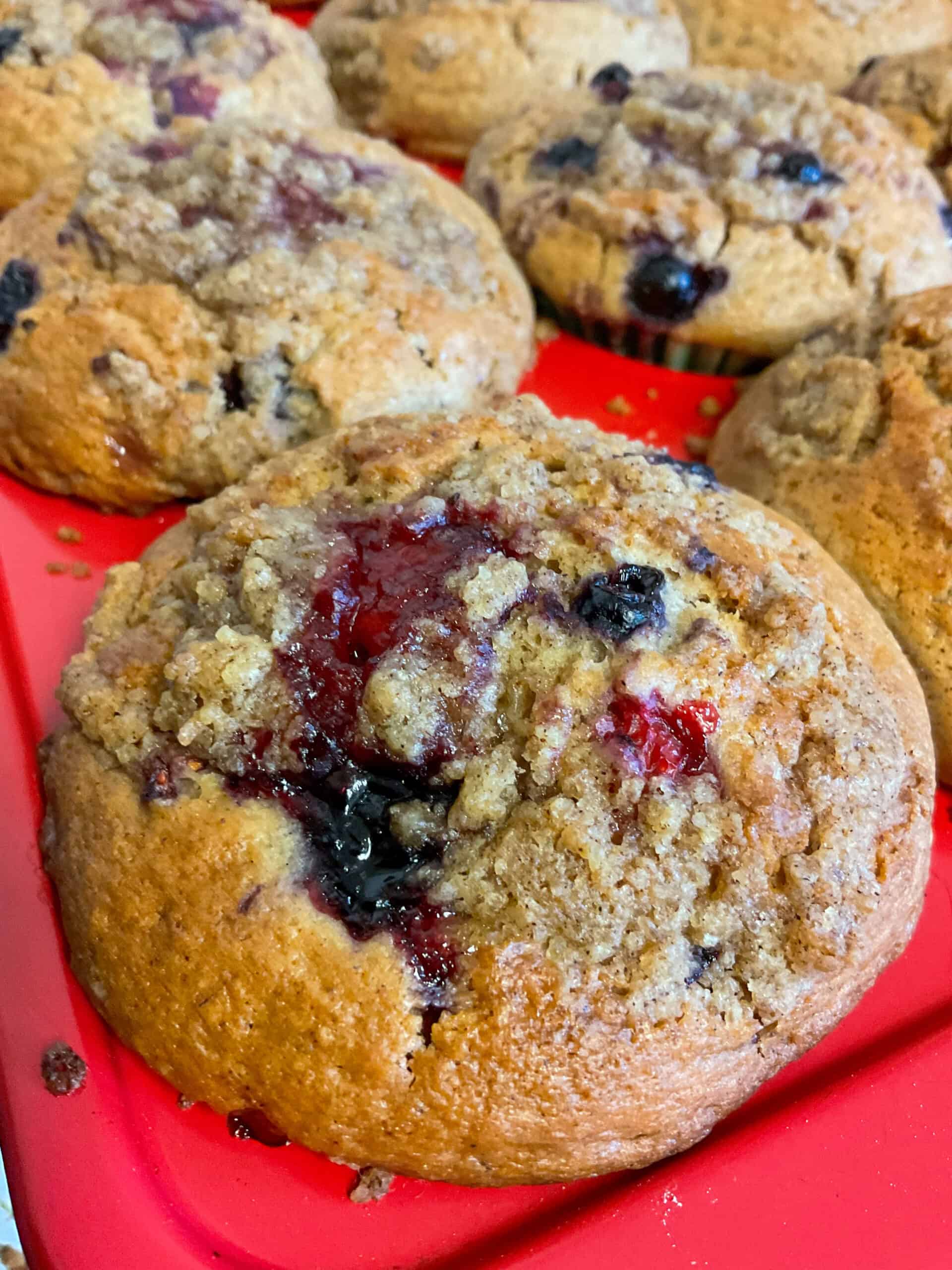 Close up of a mixed berry muffins baked and in muffin pan.