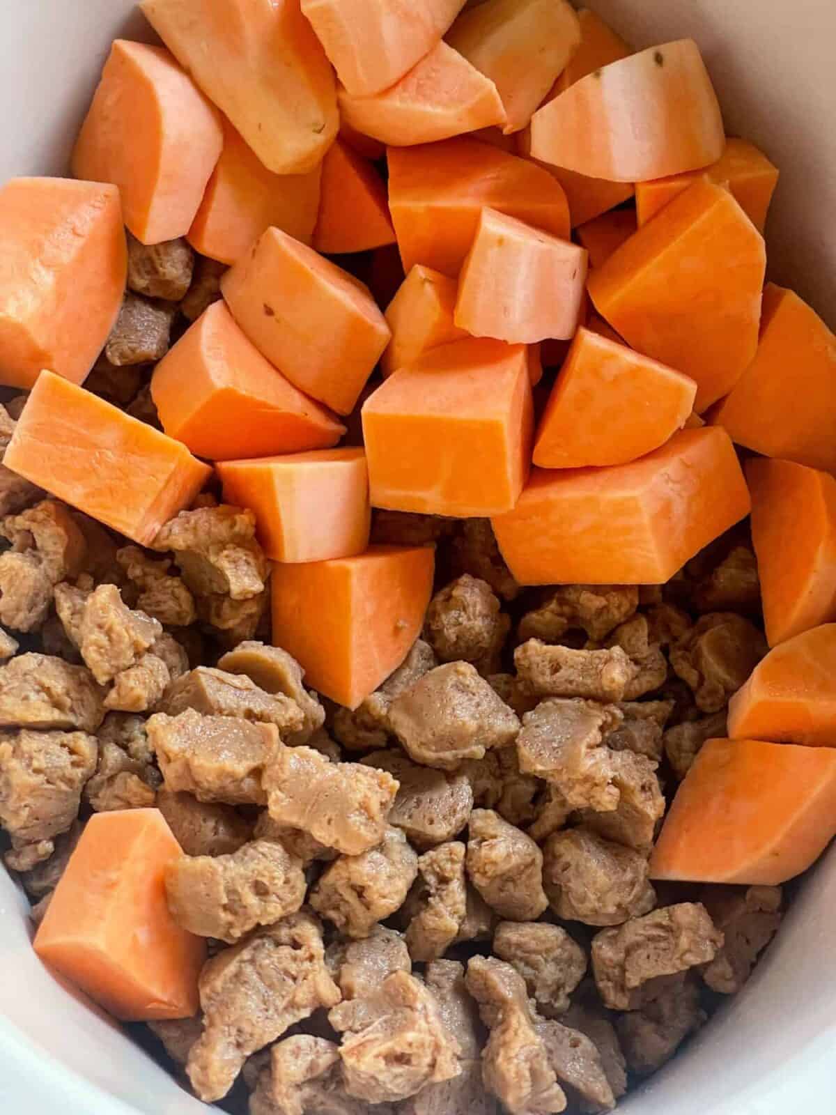 Sweet potato added to soya chunks in slow cooker.