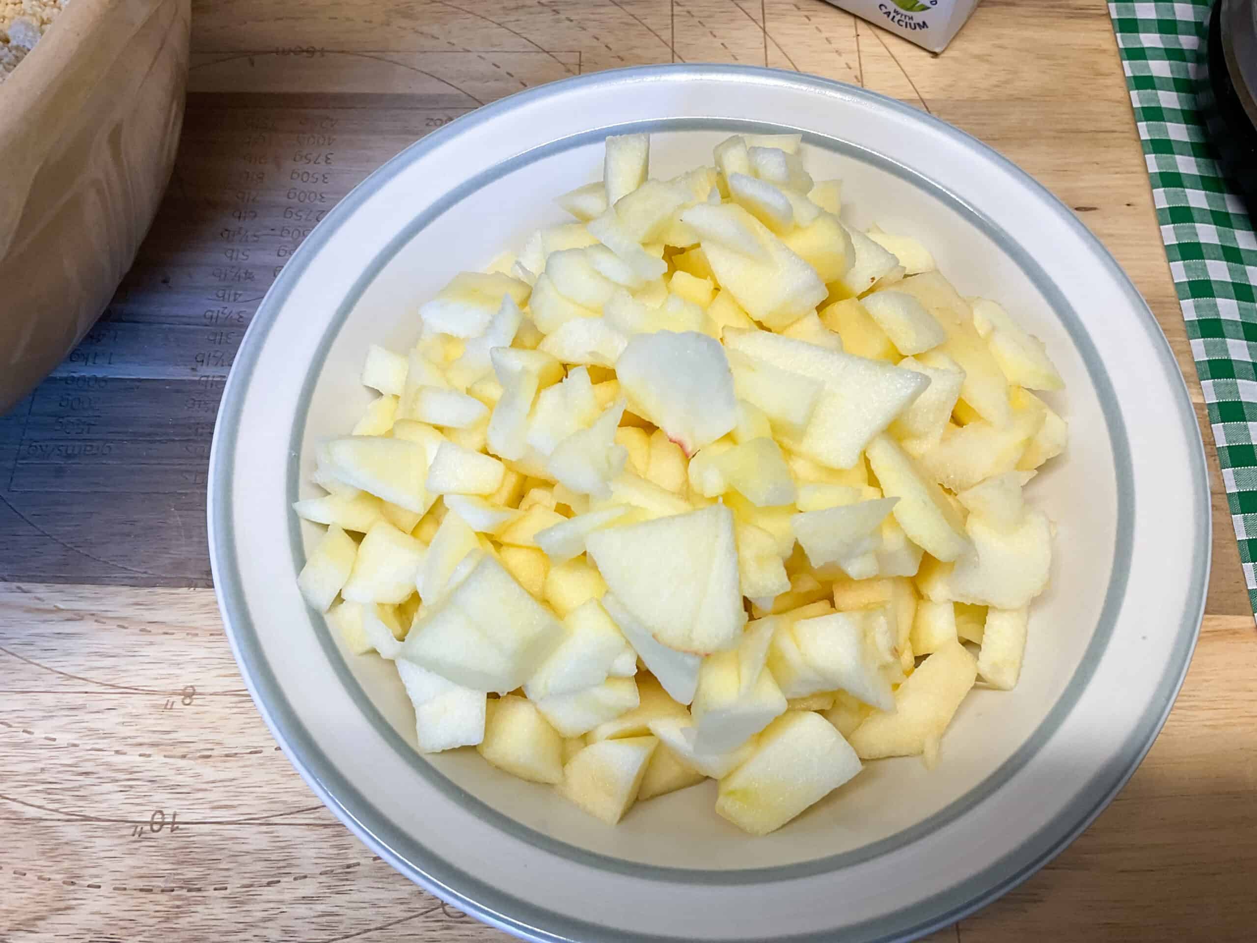 Apples chopped into small pieces in a small bowl.
