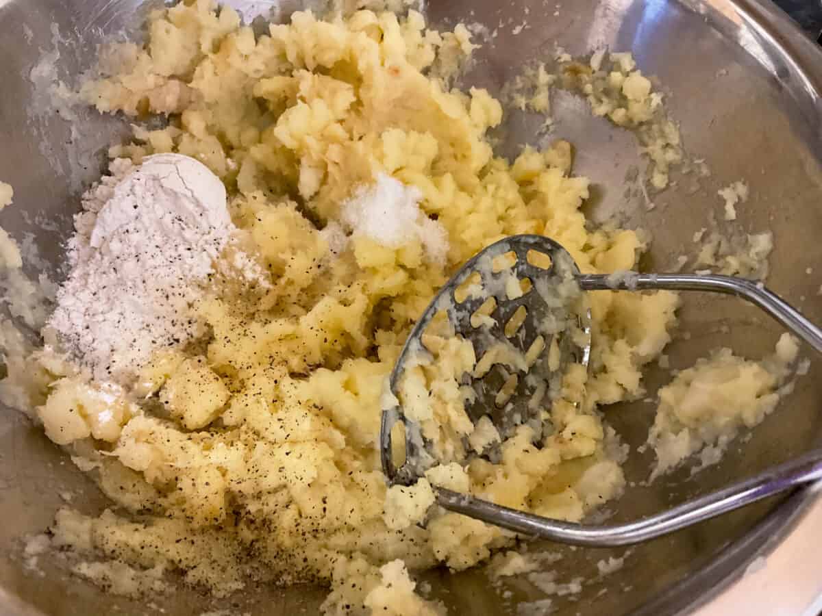 Flour and seasonings added to mashed parsnips in bowl.