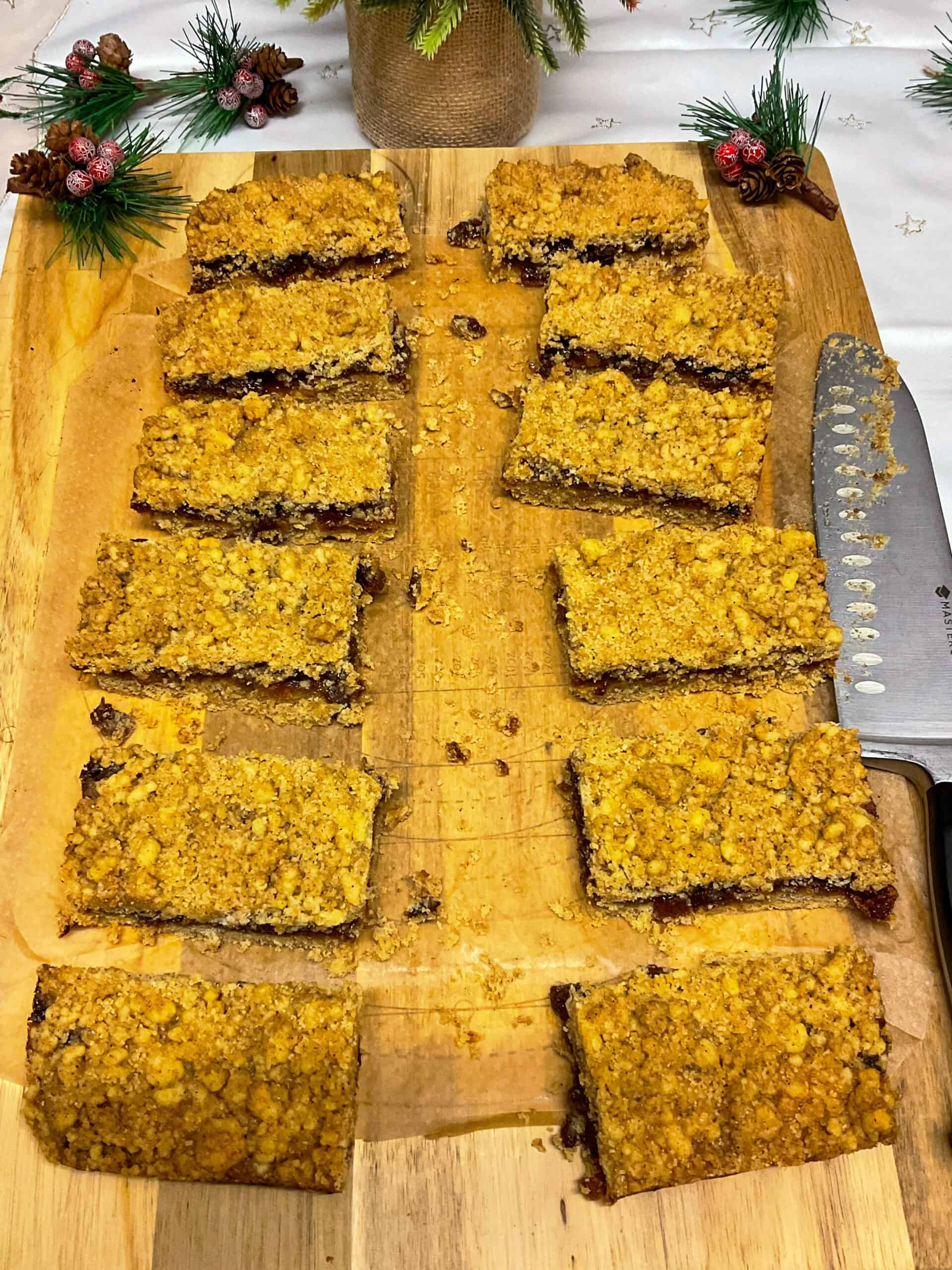 Mincemeat crumble traybake sliced into 12 bars on a cutting board.