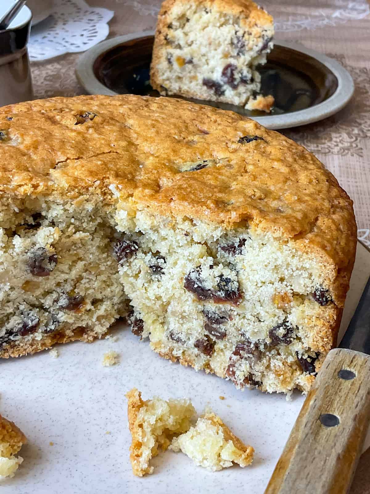 Cake with slices cut and one slice in background on small serving plate.