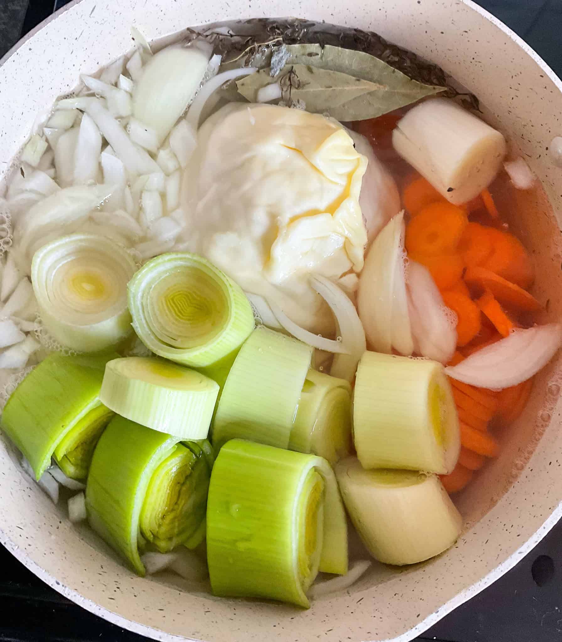 Raw vegetables added to soup pot.
