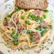 Vegan Spaghetti Carbonara served on plate with bread.