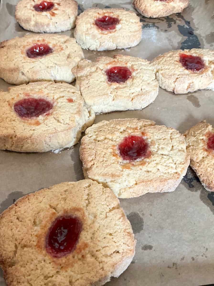 Jam cushion biscuits on baking tray.