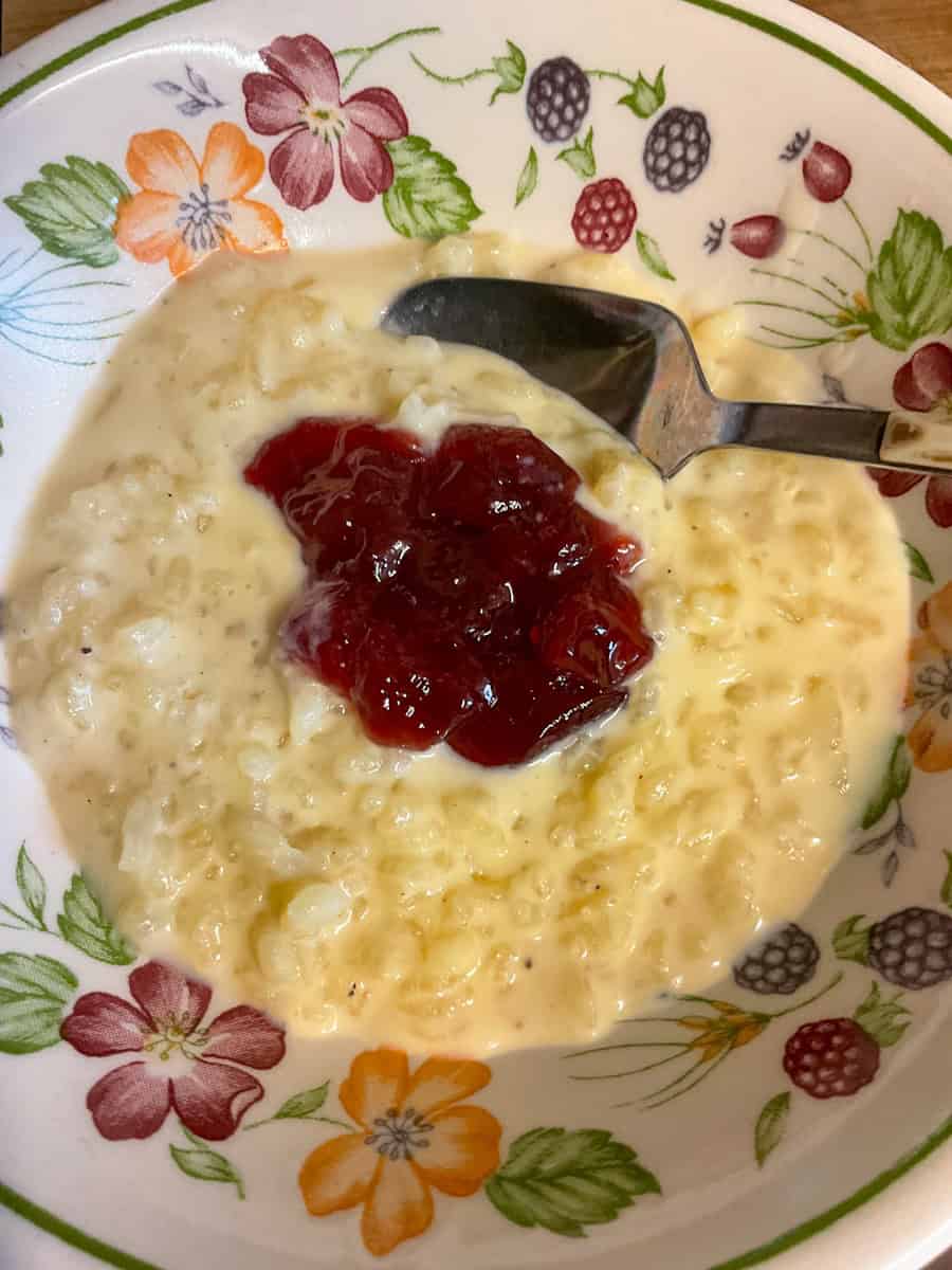 Baked rice pudding in flower patterned bowl with spoon.
