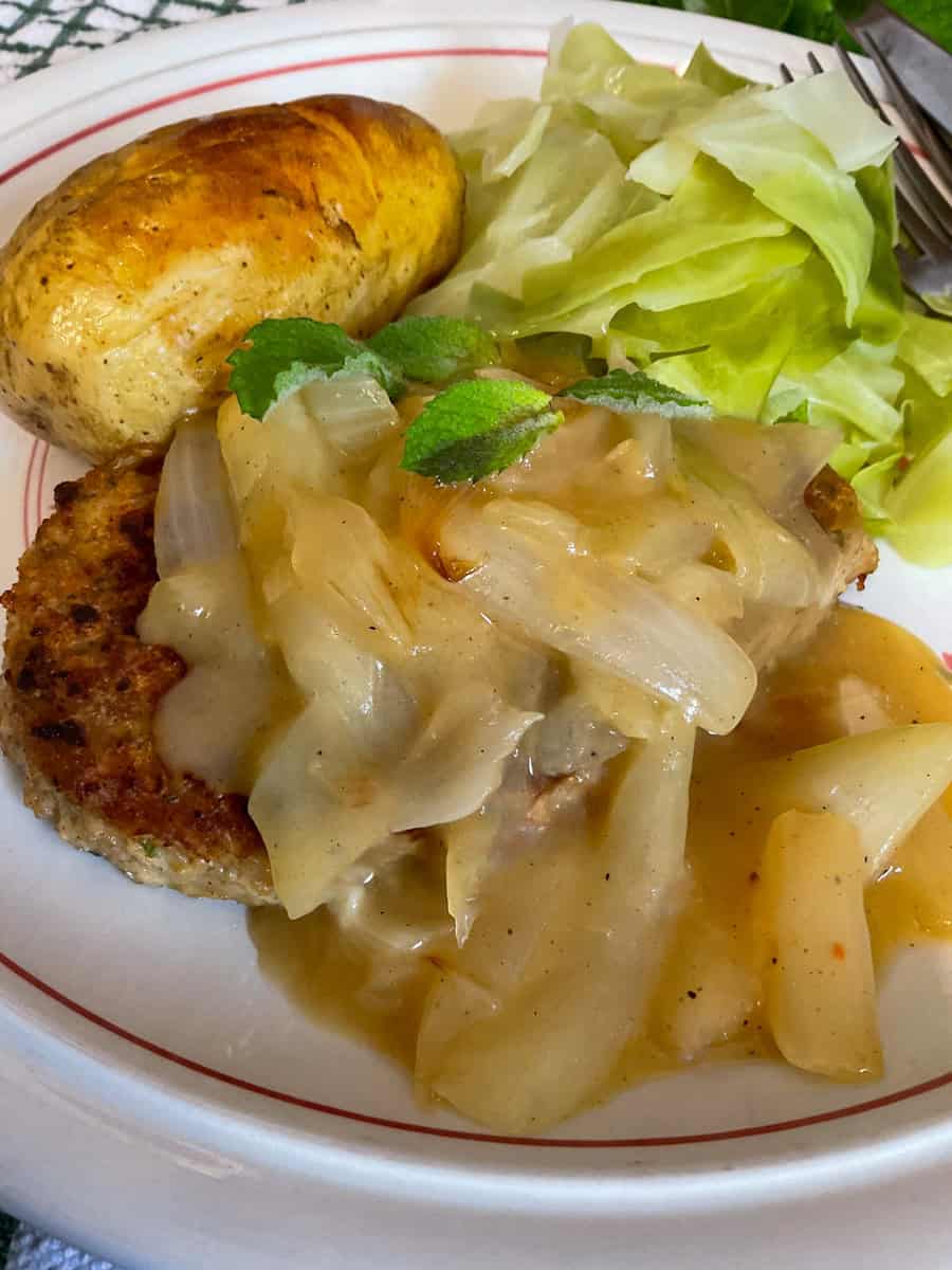 Vegan cutlets with onion sauce served with cabbage and baked potatoes.