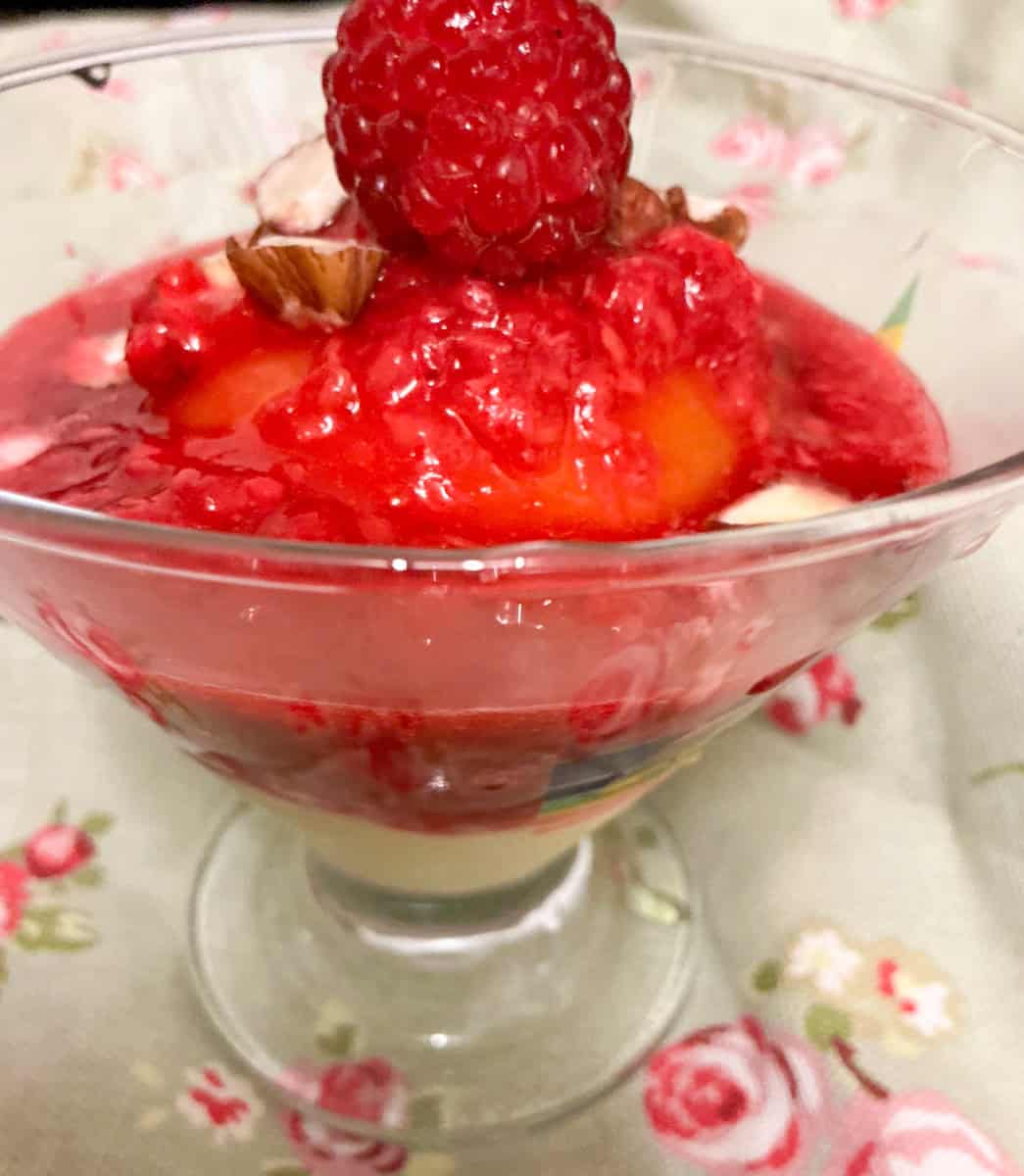 Vegan peach melba served in small glass dish.