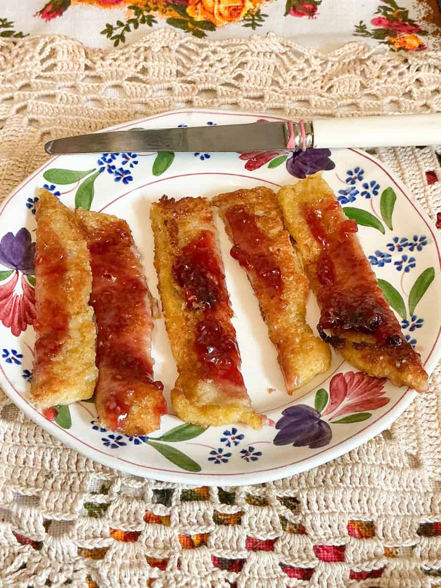 Vegan Poor Knights of Windsor served on plate with butter knife.